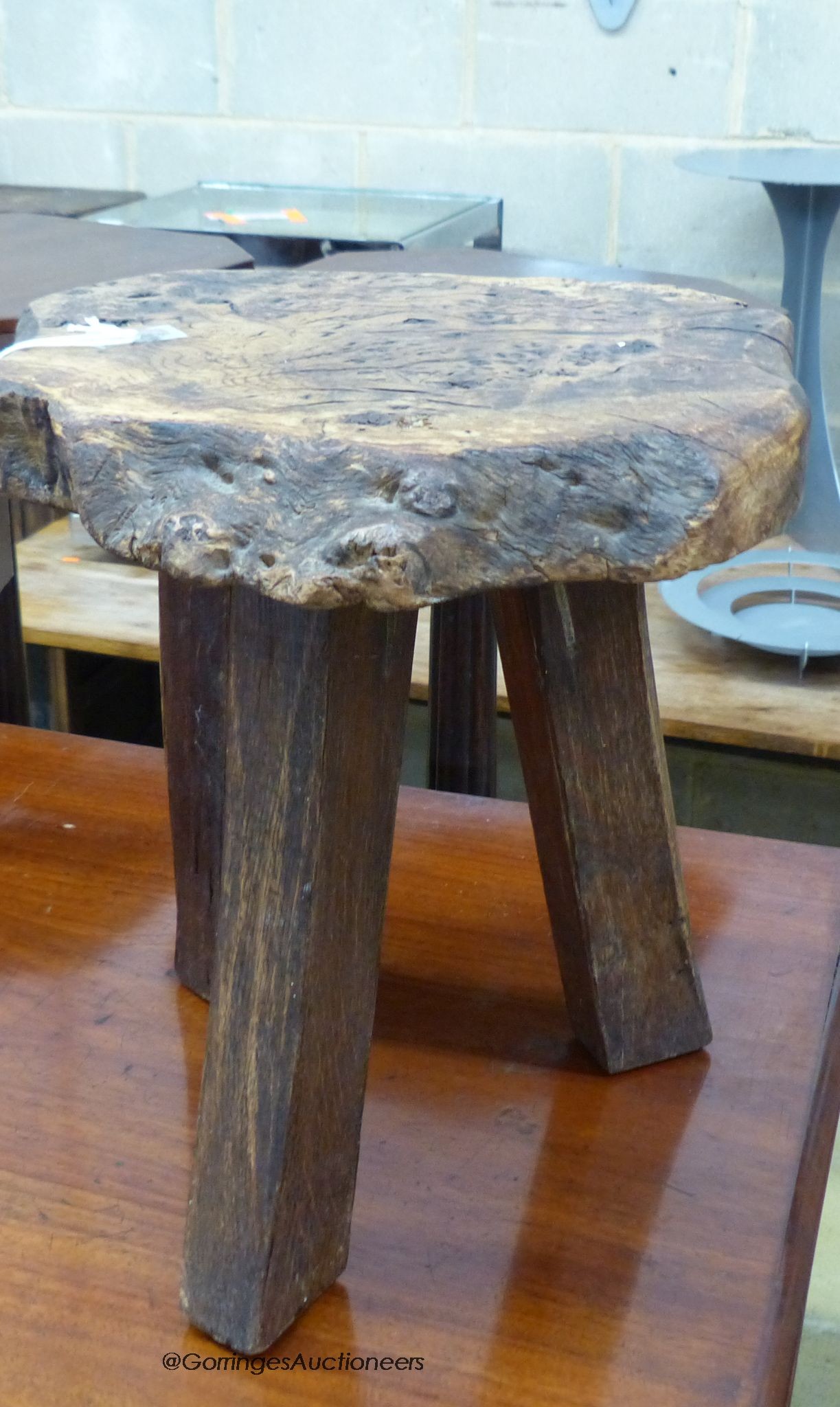 A provincial burr ash topped tripod stool, stamped Wanderwood, width 32cm, height 33cm